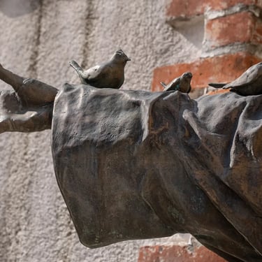 Open hand of the statue with perched birds, symbolizing peace and brotherhood.
