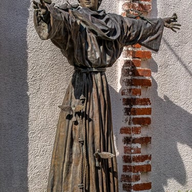 Front view of the entire Saint Francis statue, figure seeming to float with birds.