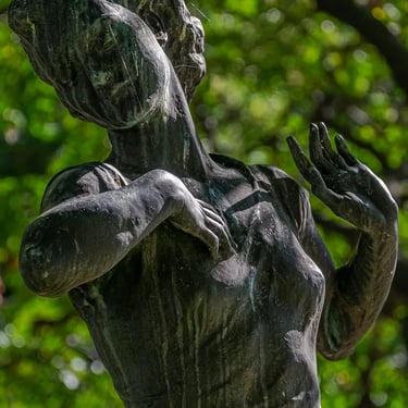 Upper body of the statue, both hands raised in a joyful greeting to spring.