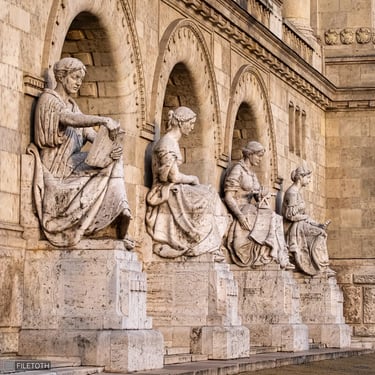 All four reconstructed statues with the main entrance of TUB, viewed from an angle.