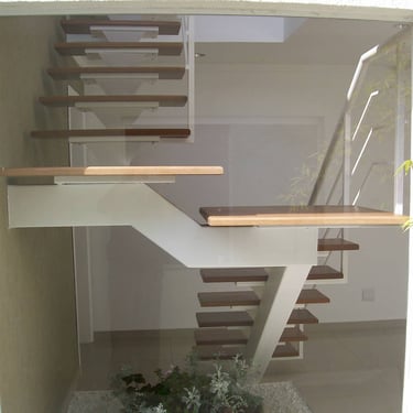 Escada de design moderno com viga central de metal branca e degraus flutuantes de madeira, vista através de uma janela de vid