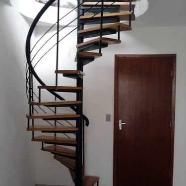 Longo guarda-corpo de vidro sem moldura (autoportante) dividindo um corredor externo de um jardim com palmeiras em um nível i