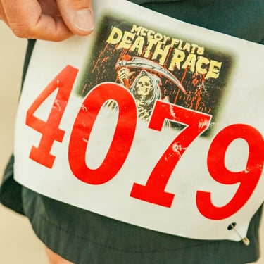 A runner's race bib for the McCoy Flats Death Race featuring number 4079 and a grim reaper graphic.