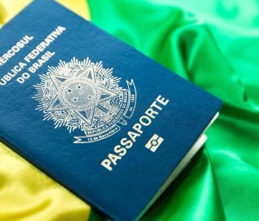 foto de um passaporte brasileiro sobre uma bandera brasileira