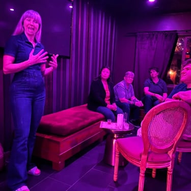Woman speaking in a purple lighting room with seated people