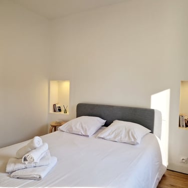 a bed with a white bed and a mirror