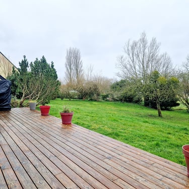 a deck with potted plants and a grill grill