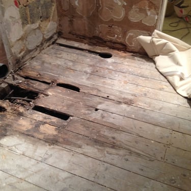 when a shower cubicle leaks over a long period time and the water gets into the floorboards. The floor rots away.