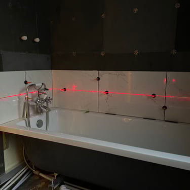 Laser level used to line up the tiles around all four walls
