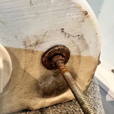 water leaking through a close coupled cistern along the retaining bolt