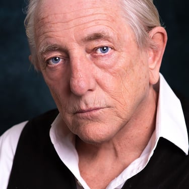 a man with a white shirt and black vest
