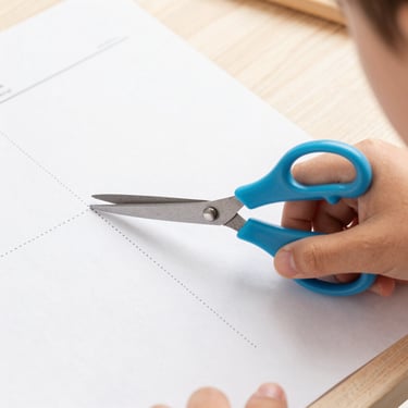 Close-up of a child's hand holding safety scissors, carefully cutting along a dotted line on a worksheet, bright daylight
