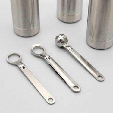 Bright high-key product photography of customized metal squeezes and water bottles on a clean light gray backdrop, sharp focus