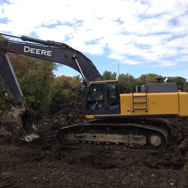 John Deere Excavator digging up dirt