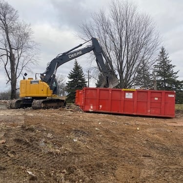 John Deere excavator putting rubble into dumpster