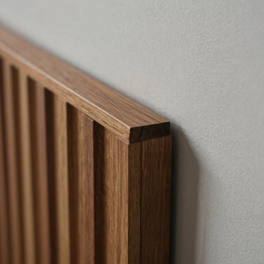 Close-up macro shot of a fluted wood panel alternative meeting a smooth matte wall, showing precise joint alignment and rich texture.