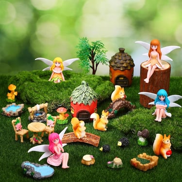 Magical fairy garden kit with miniature figurines, fairies, squirrels, and tiny houses on mossy grass.