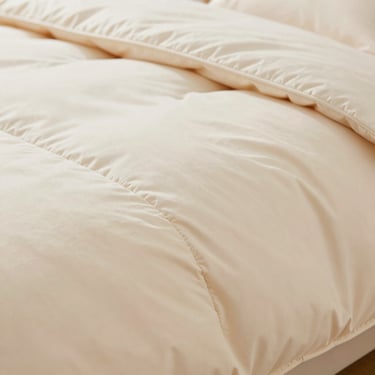 Close-up of a premium weighted blanket texture with clean double-reinforced seams, warm lighting, macro shot