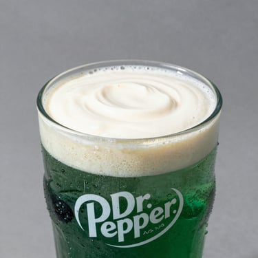 Dr. Pepper soda mixed with rich vanilla cream and blackberry syrup, high contrast