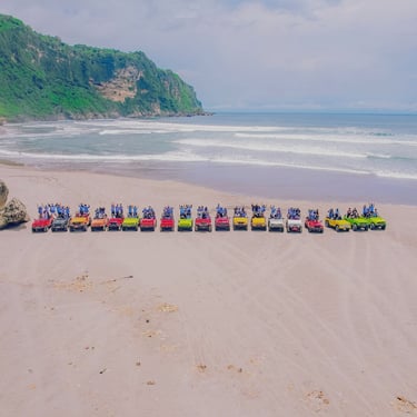 Jeep Parangtritis melintasi jalur pasir dengan latar Gumuk Pasir Yogyakarta