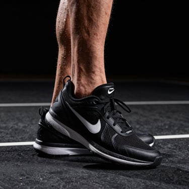 Extreme close-up of an athlete's footwork executing a sharp pivot on a dark indoor court, harsh spotlight emphasizing muscle tension and shoe grip.