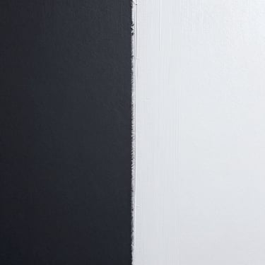 Crisp edge of fresh white paint meeting a dark charcoal wall, flawless clean line, architectural lighting.