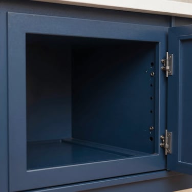 Close-up elevation of a double shaker cabinet door, dimensional stepped inner profile, deep navy finish, daylight.