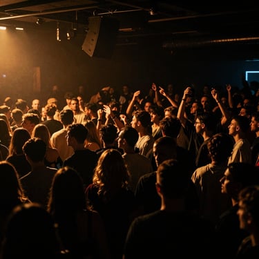 Wide atmospheric venue shot of a packed dancefloor, dark shadows with electric amber accents, high contrast.
