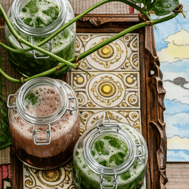 Vista aerea de 3 frascos de kombucha sobre una mesa.