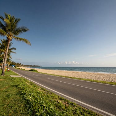 Wide-angle photograph of a pristine commercial beachfront parcel in Samal, showing direct road access and clear sandy shores under bright daylight.