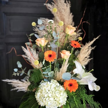 Composition florale en fleurs séchées, tons blanc, orange et vert, réalisée par l'Ensorce'Fleurs