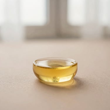 Macro shot of pure rosehip seed oil, golden liquid, soft shadows