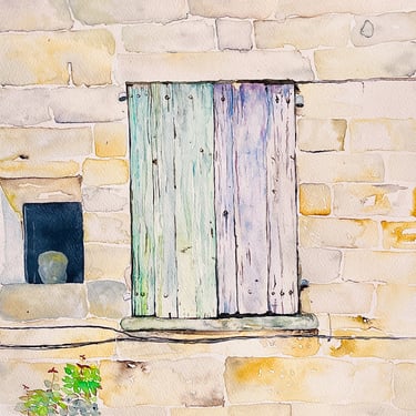 Weathered pale green wooden shutters on beige stone façade