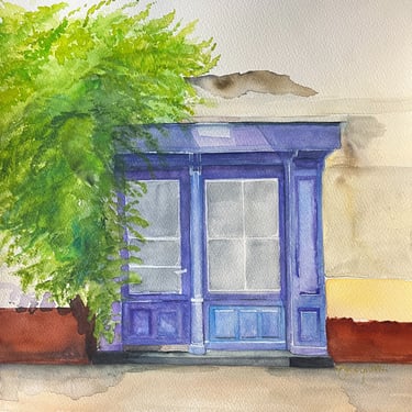 Deep blue wooden door framed by restrained greenery within mineral European façade