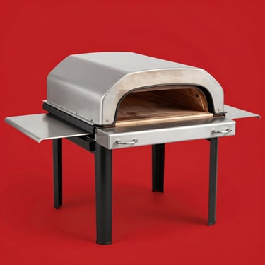 Isolated product shot of a heavy-duty portable pizza oven for backyards, bright high-key lighting, vibrant cherry red backdrop, sharp focus