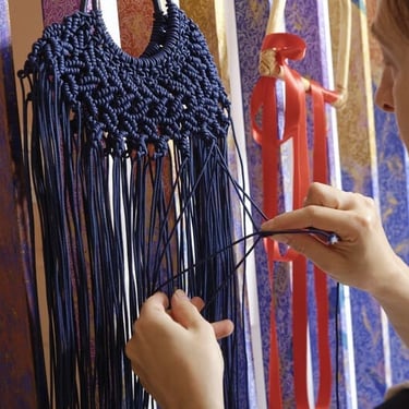 artesana haciendo prenda de macramé