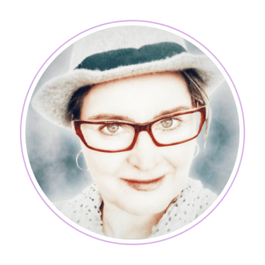 portrait picture of digital artist Dala Haspen in a hat on and glasses 