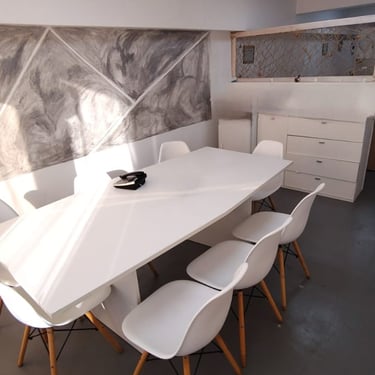 Sala de firmas en Red de Llaves, con mesa blanca, sillas modernas y luz natural por ventanales.