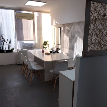 Sala de reuniones en Red de Llaves, con mesa blanca, sillas modernas y luz natural suave.