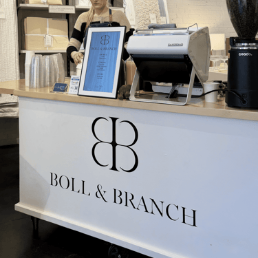 Barista preparing latte at custom branded mobile coffee cart for Boll & Branch corporate event in Dallas