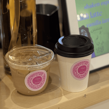 Custom branded hot and cold coffee drinks with event stickers on mobile espresso cart