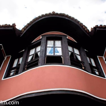 A colour photograph taken from below featuring the top story of an old European house