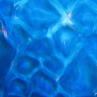 An abstract cold toned photograph featuring out-of-focus bubbles