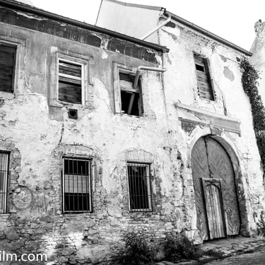 A black & white photo of an old decrepit two storey building