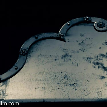 A cold toned close-up photograph of an antique looking glass