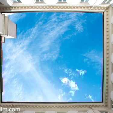 A dramatic colour photo featuring a view from below of a traditional European building’s courtyard 