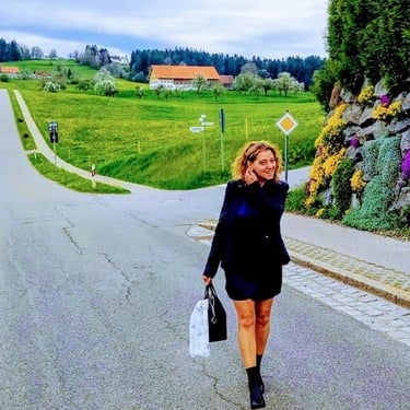 a woman walking down a street with a bag of luggage