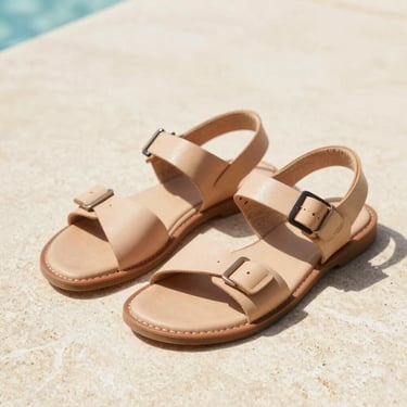 Detailed shot of comfortable leather sandals on a light stone surface, soft shadows