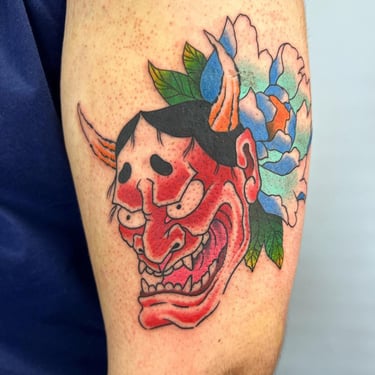 a tattoo of a demon mask on a man's arm made at Inari Tattoo