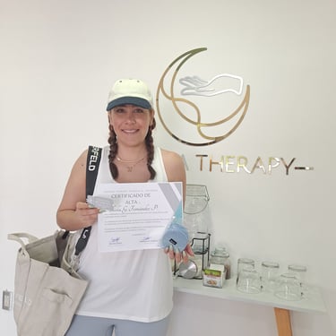 Paciente sonriente mostrando el certificado de alta y una taza de regalo tras completar su rehabilitación con éxito